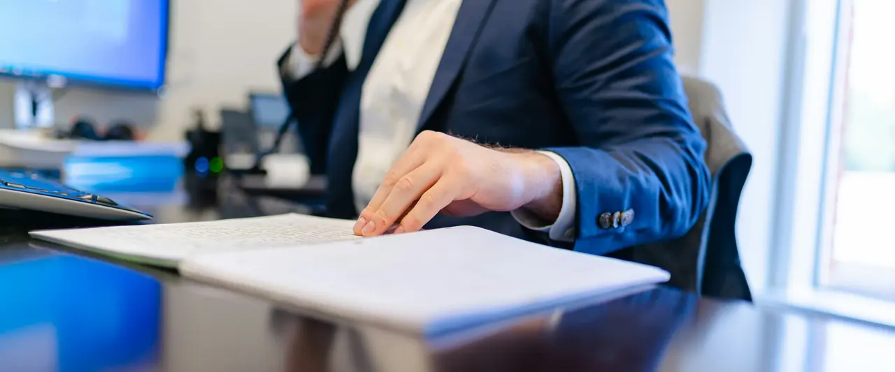 Professionnel annotant un dossier à son bureau