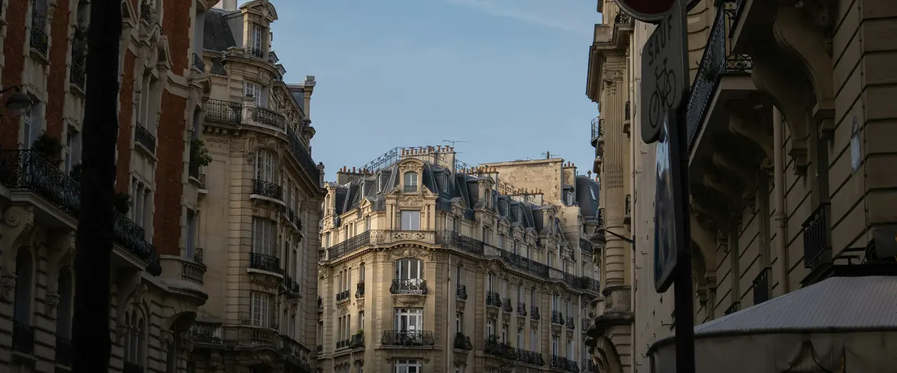 Rue bordée d’immeubles de rapport à la tombée du jour