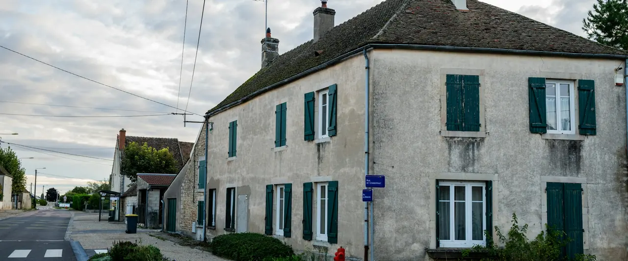 Maison de village aux volets verts, en bord de rue